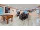 Finished basement showcasing a foosball table, a relaxation area, and wood-look laminate flooring at 23882 E Alabama Dr, Aurora, CO 80018