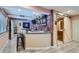 Finished basement bar featuring brick accent wall, barstool seating, and modern shelving at 23882 E Alabama Dr, Aurora, CO 80018
