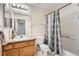 Cozy bathroom showcasing a shower-tub combination, a toilet, and a single sink vanity with storage at 23882 E Alabama Dr, Aurora, CO 80018