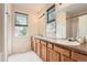 Well-lit bathroom featuring a dual sink vanity, and a large mirror and window with blinds at 23882 E Alabama Dr, Aurora, CO 80018