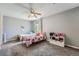 Neutral bedroom featuring two beds, a ceiling fan, and a toy shelf for optimal organization and storage at 23882 E Alabama Dr, Aurora, CO 80018