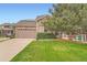 Inviting home with a manicured lawn, mature trees, and a stone-accented facade at 23882 E Alabama Dr, Aurora, CO 80018