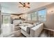 Open concept living room with a kitchen view, large windows, and modern ceiling fan at 23882 E Alabama Dr, Aurora, CO 80018