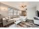 Bright living room featuring a large sectional sofa, ceiling fan, and wood-look floors at 23882 E Alabama Dr, Aurora, CO 80018
