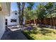 Backyard featuring a mature tree, a brick patio, lush lawn, and a wooden fence providing privacy at 5195 Allison St, Arvada, CO 80002