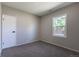 Clean bedroom with neutral carpet and paint. Flooded with natural light from a window overlooking a wooded yard at 5195 Allison St, Arvada, CO 80002