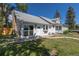 Exterior view of a charming home featuring stone chimney and mature trees on a sunny day at 5195 Allison St, Arvada, CO 80002