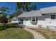 Bright white home with a well-maintained lawn, a charming front door, and a walkway leading to the entrance at 5195 Allison St, Arvada, CO 80002
