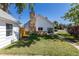 Charming white home with a stone chimney and manicured lawn, surrounded by lush greenery and clear blue skies at 5195 Allison St, Arvada, CO 80002