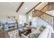 Stylish living room offering a fireplace, wood beams, and an open layout with staircase at 5195 Allison St, Arvada, CO 80002