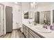 White bathroom featuring double sinks, grey cabinets, and tiled floor at 18657 Stroh Rd # 4103, Parker, CO 80134