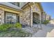 Apartment building entrance with stone accents, green door, landscaping, and walkway at 18657 Stroh Rd # 4103, Parker, CO 80134