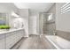 Well-lit bathroom featuring double vanity, a soaking tub, and a glass-enclosed shower at 9340 Mount Jackson St, Littleton, CO 80125