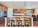 Bright kitchen boasts granite counters, stainless appliances, wood cabinets and island with bar seating at 13987 Lexington Dr, Parker, CO 80134