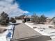 Ranch style home exterior with a two car garage and snow covered landscaping at 7260 Fallon Cir, Castle Rock, CO 80104