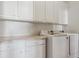 Bright laundry room with washer, dryer, and white cabinets at 7260 Fallon Cir, Castle Rock, CO 80104