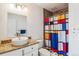 Beautiful bathroom featuring granite vanity, modern vessel sink, decorative tile, and bright shower curtain at 795 S Alton Way # 5D, Denver, CO 80247