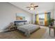 A bedroom features a blue bed, window with curtains, ceiling fan, and neutral walls at 795 S Alton Way # 5D, Denver, CO 80247