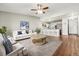 Open concept living room with white sofa, wooden table, and wood flooring at 795 S Alton Way # 5D, Denver, CO 80247