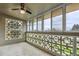 Enclosed sunroom featuring walls of windows, privacy screens, and an overhead ceiling fan at 795 S Alton Way # 5D, Denver, CO 80247