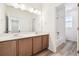 Bathroom with double vanity, mirror, and tub shower combo at 6575 N Nepal St, Aurora, CO 80019