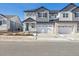 Two-story townhome with gray and white siding, two-car garage, and a paved driveway at 6575 N Nepal St, Aurora, CO 80019