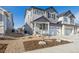 Two-story townhome with gray and white siding, two-car garage, and small front yard at 6575 N Nepal St, Aurora, CO 80019