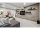 Open basement with seating, shelving, and entertainment area at 8890 S Quatar Ct, Aurora, CO 80016