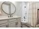 Bright bathroom with a large vanity, decorative mirror, and tiled shower at 8890 S Quatar Ct, Aurora, CO 80016