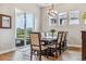 Elegant dining room with a large wooden table, stylish chairs, and abundant natural light at 8890 S Quatar Ct, Aurora, CO 80016