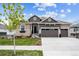 Inviting home with manicured lawn, three-car garage, and charming architectural details at 8890 S Quatar Ct, Aurora, CO 80016