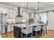 Modern kitchen with stainless steel appliances, a large island with bar seating, and stylish lighting at 8890 S Quatar Ct, Aurora, CO 80016