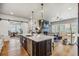 Open concept kitchen with large island, stainless appliances, and a view of the living room with fireplace at 8890 S Quatar Ct, Aurora, CO 80016
