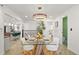 Modern dining room with glass-top table, white chairs, and a stylish light fixture at 190 W 1St Ave, Broomfield, CO 80020