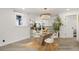 Modern dining room with glass top table, white chairs and view into kitchen at 190 W 1St Ave, Broomfield, CO 80020