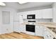 Well-lit kitchen featuring white cabinets, laminate counters, and appliances for easy meal preparation at 31819 Rocky Village Dr # 418, Evergreen, CO 80439