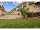 A three story apartment building exterior with balconies, green grass and gravel ground at 7335 E Quincy Ave # 107, Denver, CO 80237