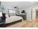 Bedroom with neutral walls, white bedding, mounted TV, and a large window at 7335 E Quincy Ave # 107, Denver, CO 80237