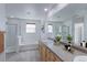 Bright bathroom features a double sink vanity, soaking tub, and separate glass enclosed shower at 2550 Winding River Dr # F2, Broomfield, CO 80023