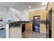 Cozy kitchen with wood cabinetry, black appliances, and tile flooring at 2550 Winding River Dr # F2, Broomfield, CO 80023