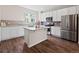 Modern kitchen with white cabinetry, stainless steel appliances, granite countertops, and center island at 1330 Independence St # 2, Lakewood, CO 80215