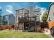 Backyard of home featuring deck, patio, fenced-in yard, and lush lawn at 14170 W Warren Dr, Lakewood, CO 80228