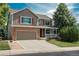 Charming two-story home with a brick and siding exterior, complemented by a well-maintained lawn and driveway at 14170 W Warren Dr, Lakewood, CO 80228