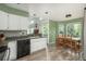 Bright eat-in kitchen boasts white cabinets, wood floors, breakfast bar, and outdoor access at 14170 W Warren Dr, Lakewood, CO 80228
