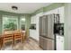 Eat-in kitchen features stainless steel refrigerator, white cabinets, and a sunny breakfast nook at 14170 W Warren Dr, Lakewood, CO 80228