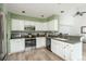 Charming kitchen features white cabinetry, stainless steel appliances, and breakfast bar at 14170 W Warren Dr, Lakewood, CO 80228
