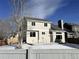 Back of the house features a neutral color scheme and a small patio in the snow-covered yard at 7246 S Pierson St, Littleton, CO 80127