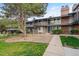Townhome exterior showcasing a well-kept lawn and mature trees at 6495 E Happy Canyon Rd # 163, Denver, CO 80237