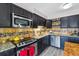 Updated kitchen with stainless steel appliances, dark cabinets, and granite countertops with modern tile backsplash at 6495 E Happy Canyon Rd # 163, Denver, CO 80237