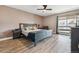 Spacious main bedroom featuring modern gray color palette, updated ceiling fan and modern wood-look floors at 6495 E Happy Canyon Rd # 163, Denver, CO 80237